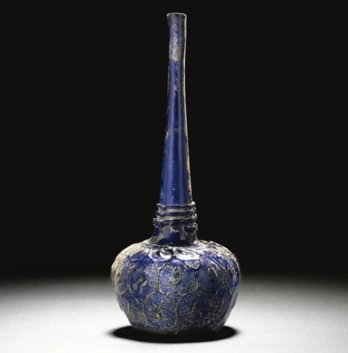 A TALL-NECKED BLUE GLASS BOTTLE